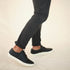 Pair of black leather Diego Everyday Sneakers with white soles worn with dark grey pants.