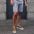 Pair of tobacco brown leather Diego Everyday Sneakers with white soles and tan laces worn with grey shorts.