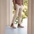 A man wears tan leather Marco Everyday Chelsea boots with dark elastic side panels, tan trousers, and a brown ribbed sweater.