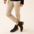 Pair of black leather Eva Everyday Chelsea Boots with tan soles worn with tan pants and a black sweater.