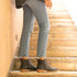 Pair of black leather Eva Everyday Chelsea boots with tan soles worn on stone stairs.